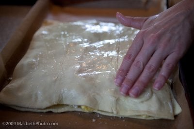Adding egg wash to top of puffed pastry so it will brown in the oven.