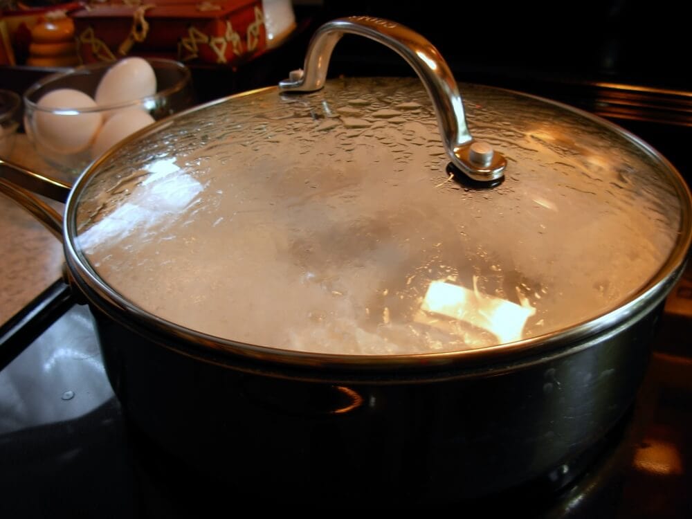 Covering eggs as they cook in shallow pan.