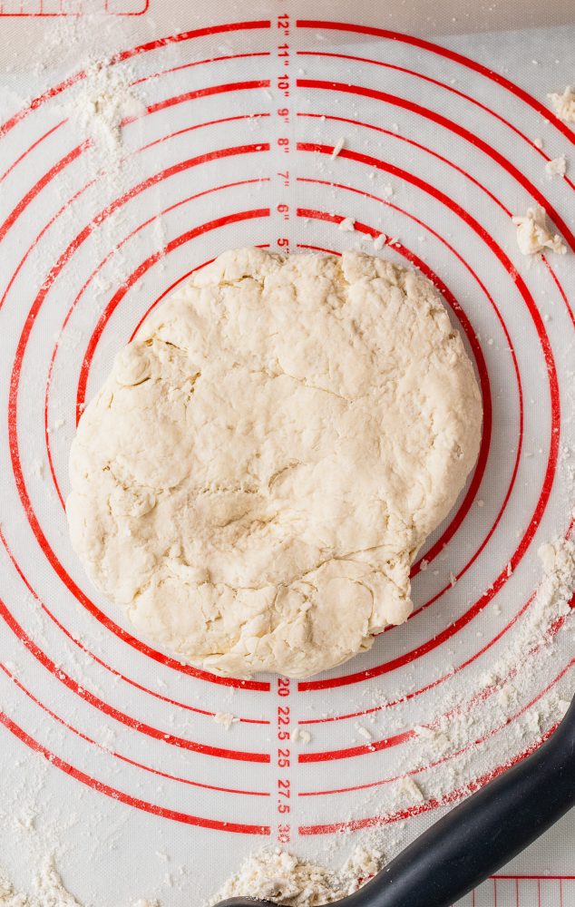Overhead shot of forming the biscuit mix into a dough ball onto a floured pastry board with measurements.