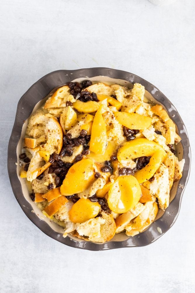 Overhead shot of showing the bread/peaches/raisins soaked with the egg mixture.