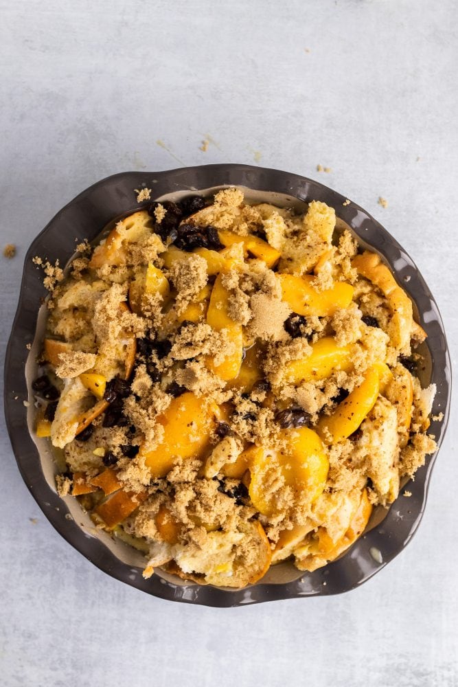 Overhead shot of pre-baked bread pudding layered with brown sugar on top.