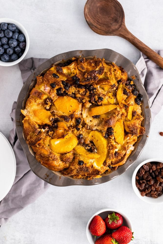 Overhead shot of bourbon bread pudding with peaches fresh baked out of the oven.