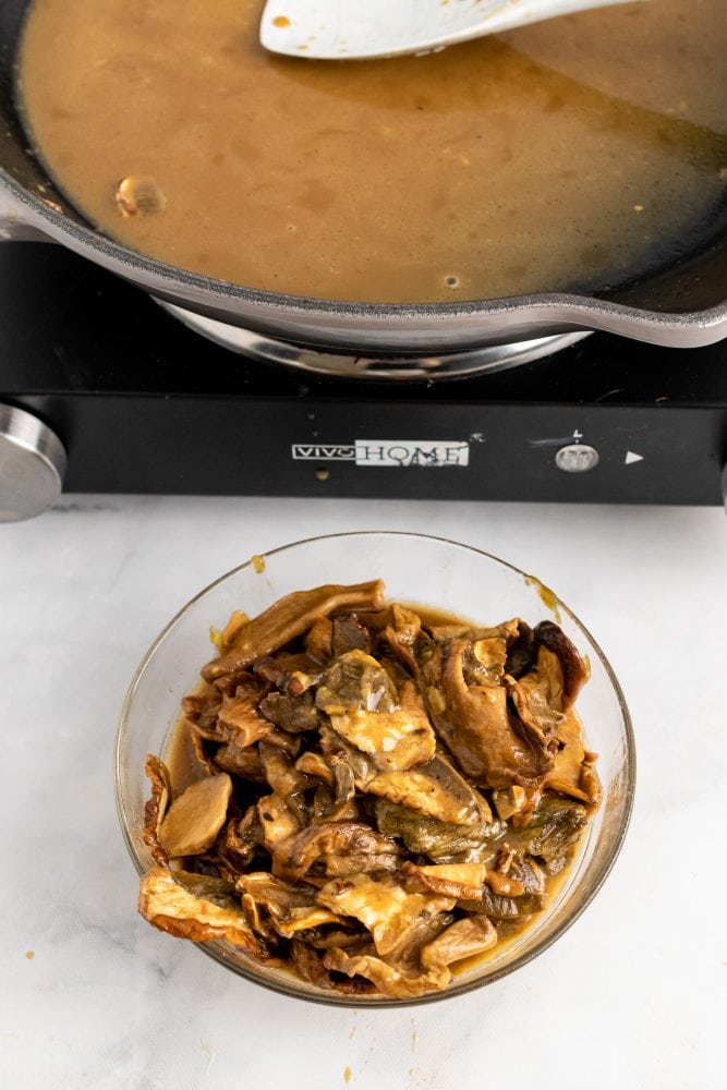 Setting aside the cooked mushrooms in a bowl.