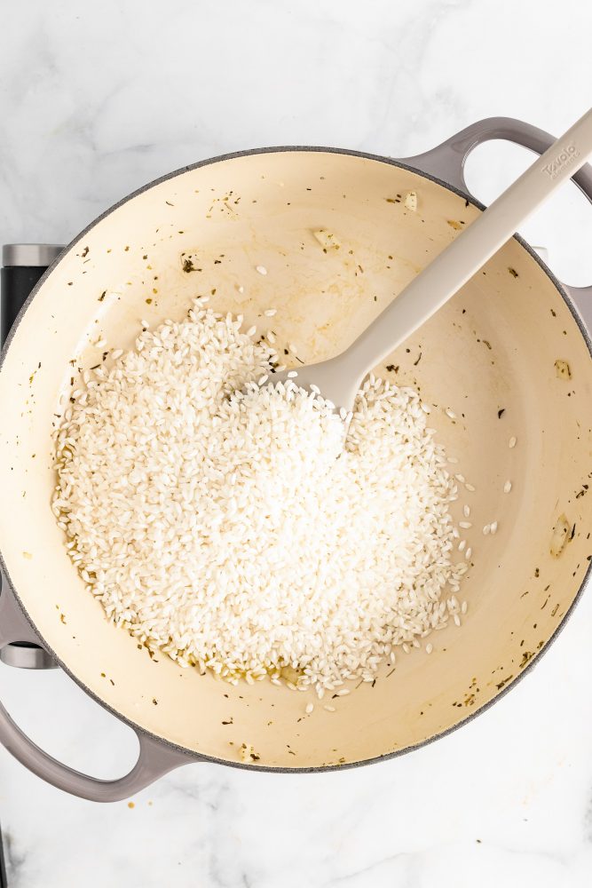 Adding the rice to the same pot that the onions were cooked in.