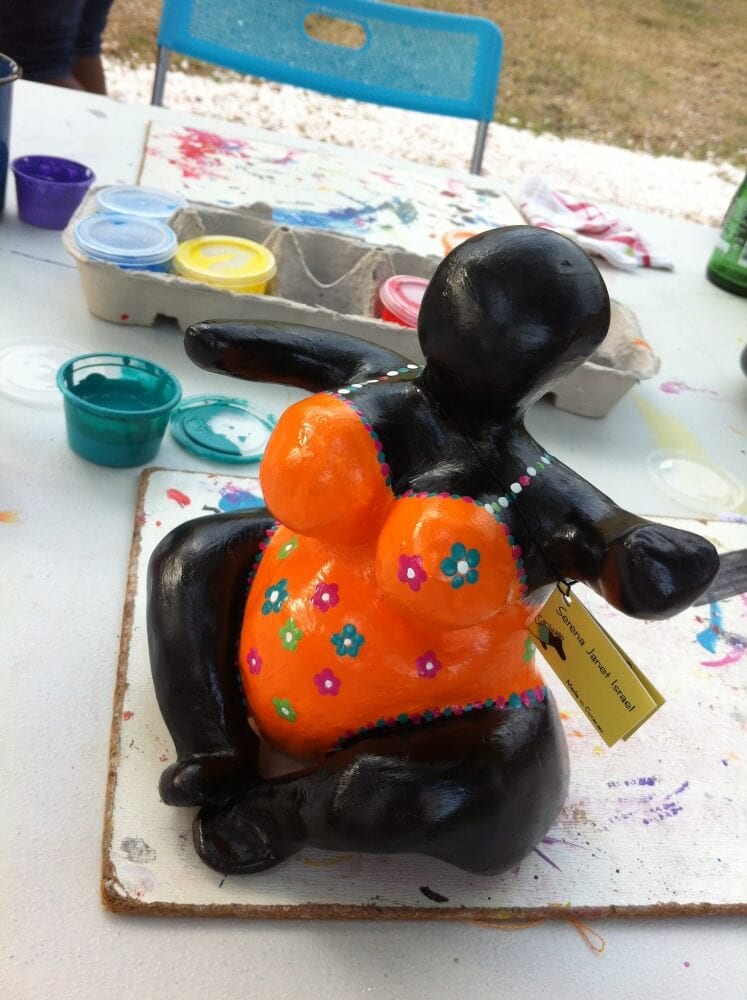 The chichi Rachelle painted in curacao with an orange bathing suite and flowers