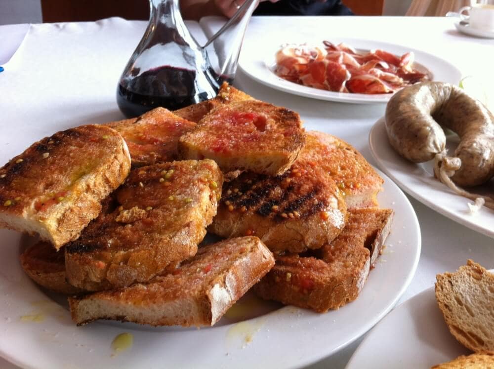 Cooking class in Spain showing how to make pa amb tomaquet, Spanish tomato bread.