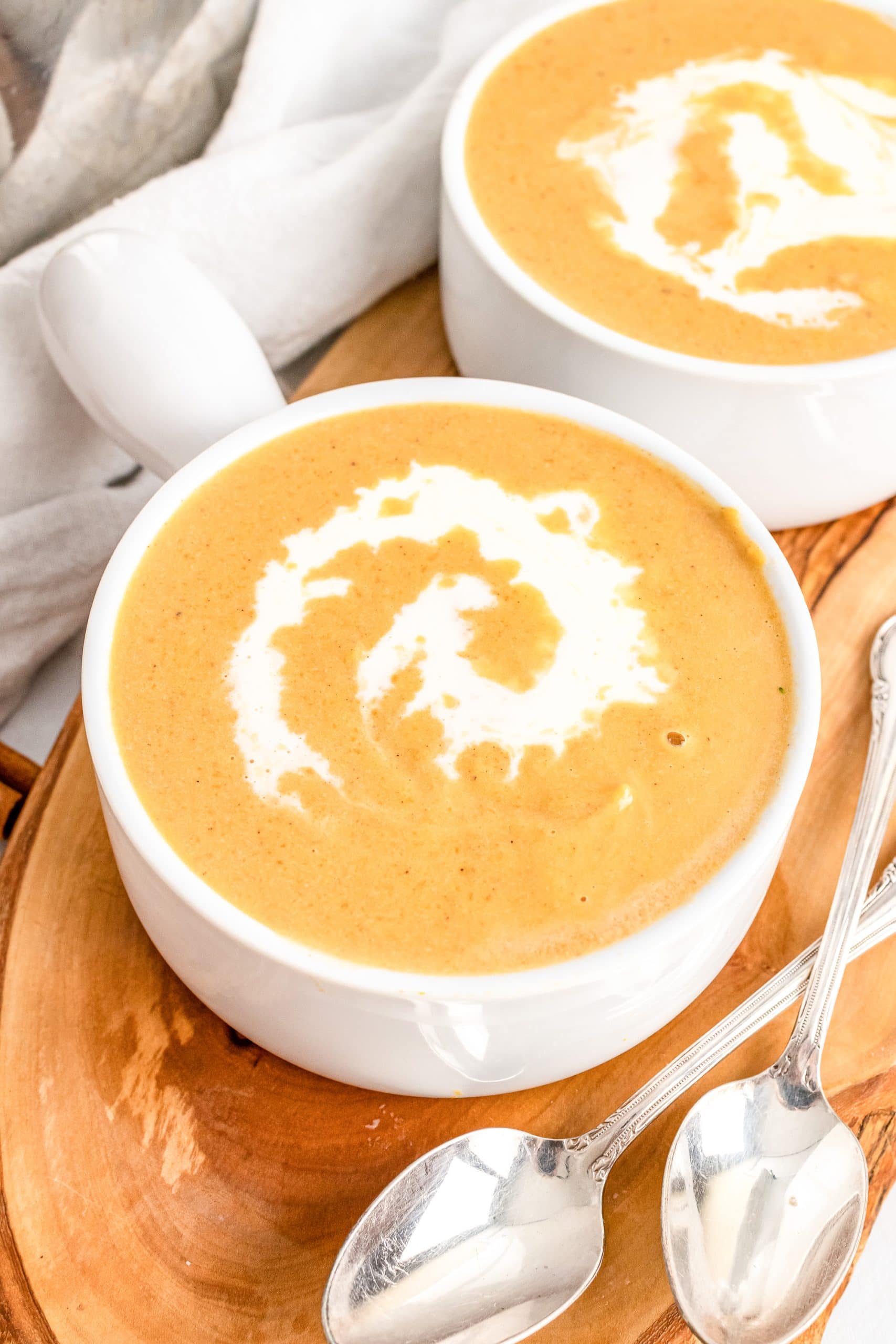 Two white bowls filled with roasted butternut squash soup.