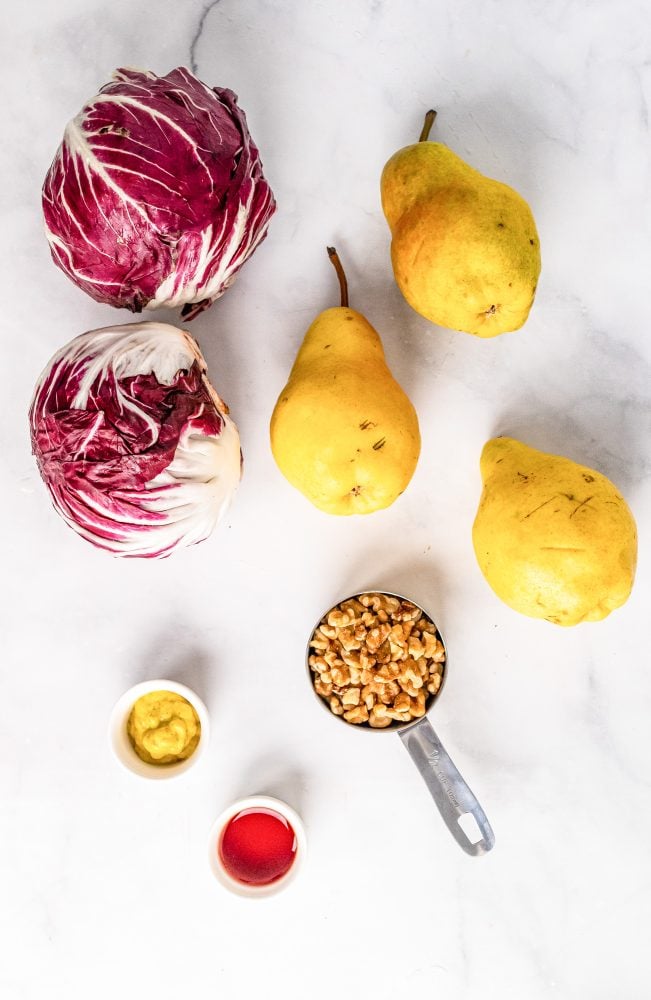 Ingredients to make this pear salad including two heads of radicchio, three pears, walnuts, dijon mustard, and red wine vinegar. 