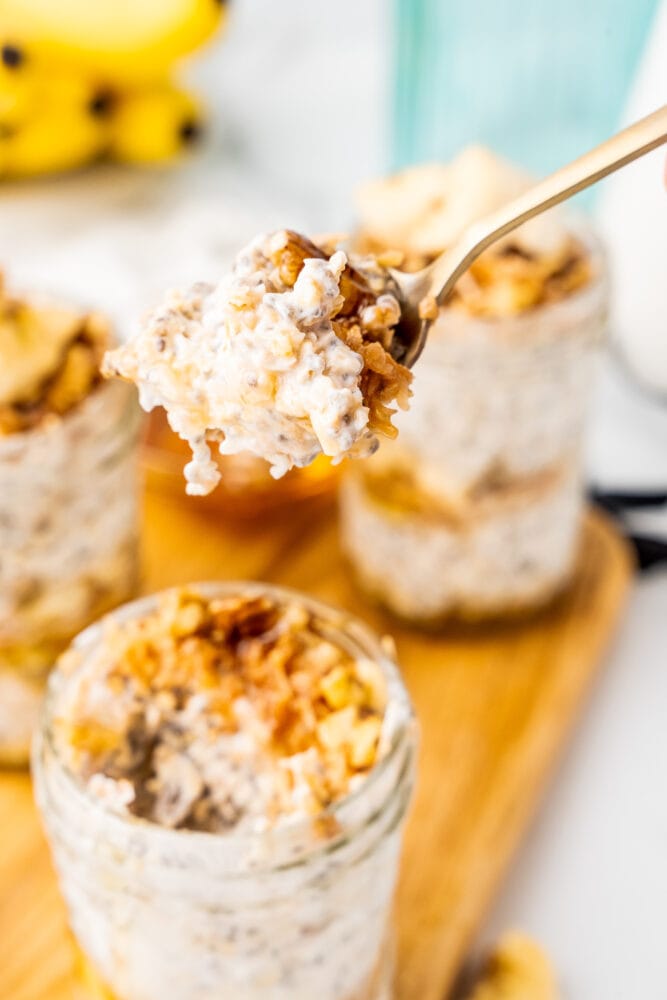 A spoonful of banana overnight oats being lifted from a jar.