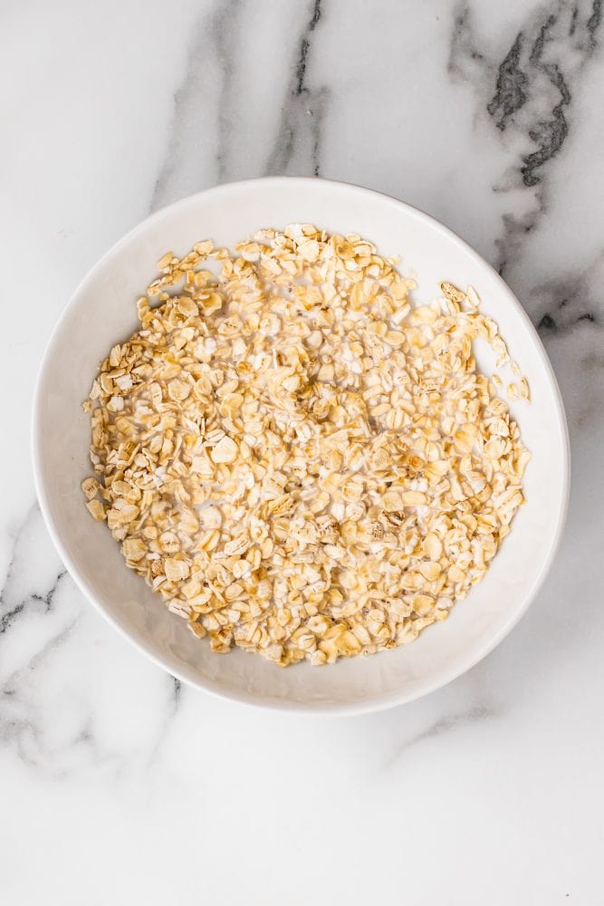 Rolled oats in a bowl soaking in milk.