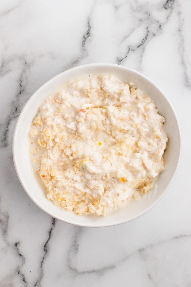 Homemade muesli in the process of becoming Bircher style muesli with oats, milk, yogurt, and grated apple blended together.