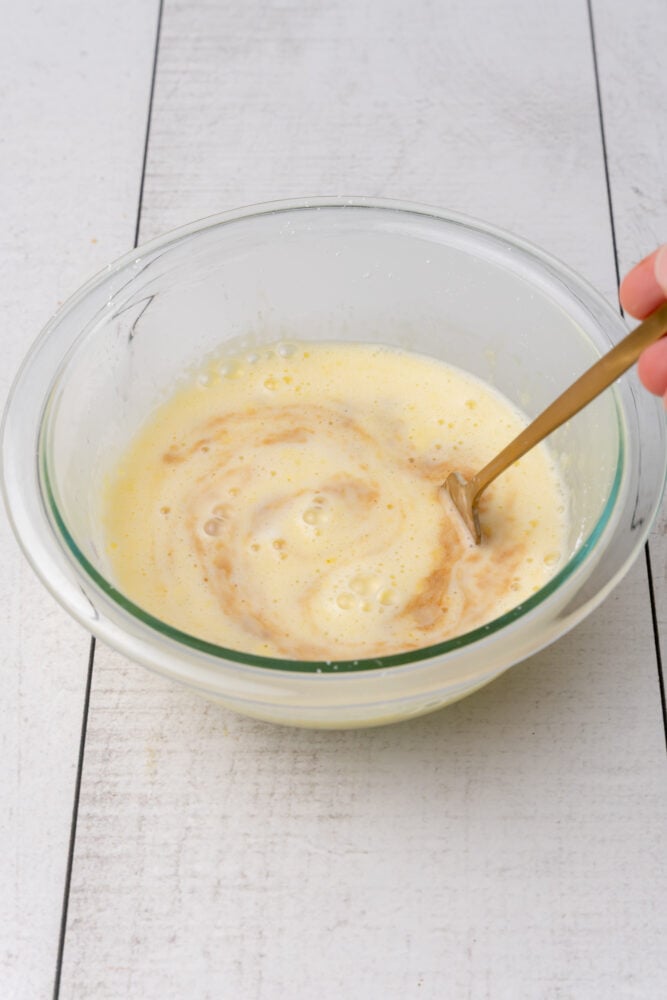 Mixing together vanilla sauce in glass mixing bowl.