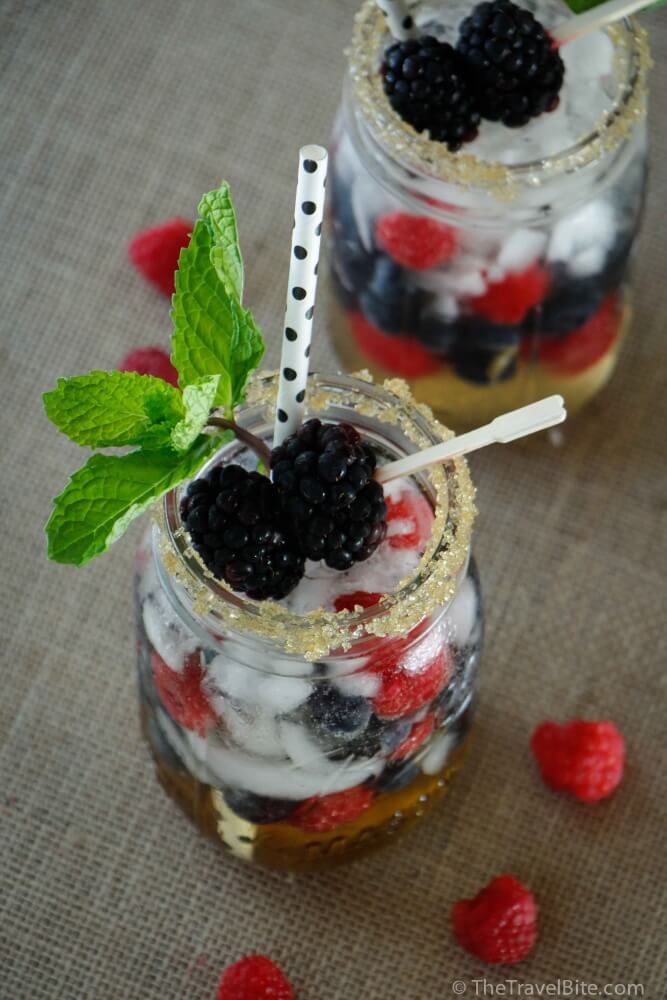 Berry Cobbler Gin Cocktail - Mason Jar with gin cocktail, polka dot straw, and blackberry and mint garnish.