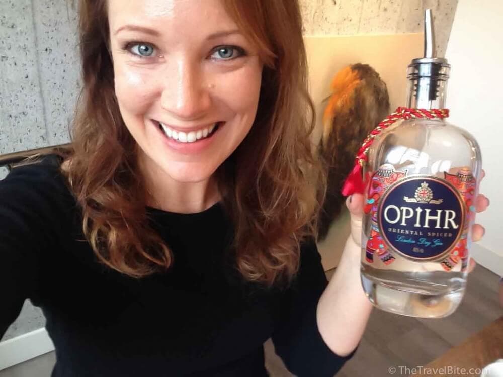 Rachelle holding a bottle of Opihr Spiced Gin.