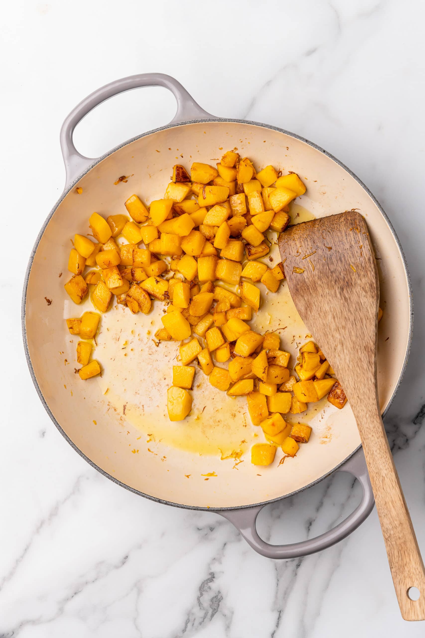 Sauted pumpkin in an enameled cast iron skillet.