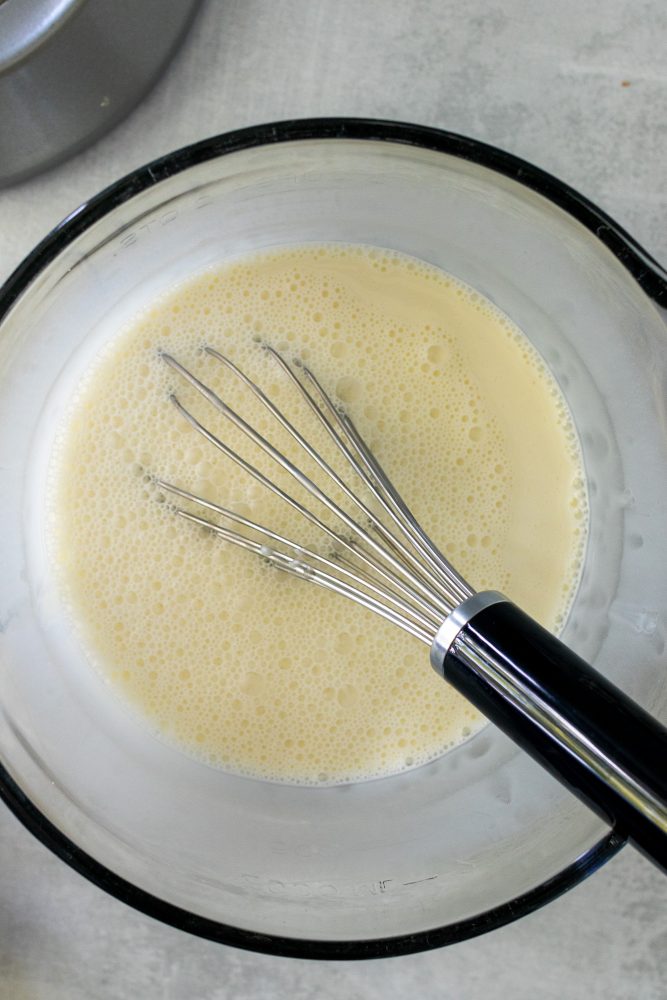 Overhead shot of half and half and sweetened condensed milk whisked together.