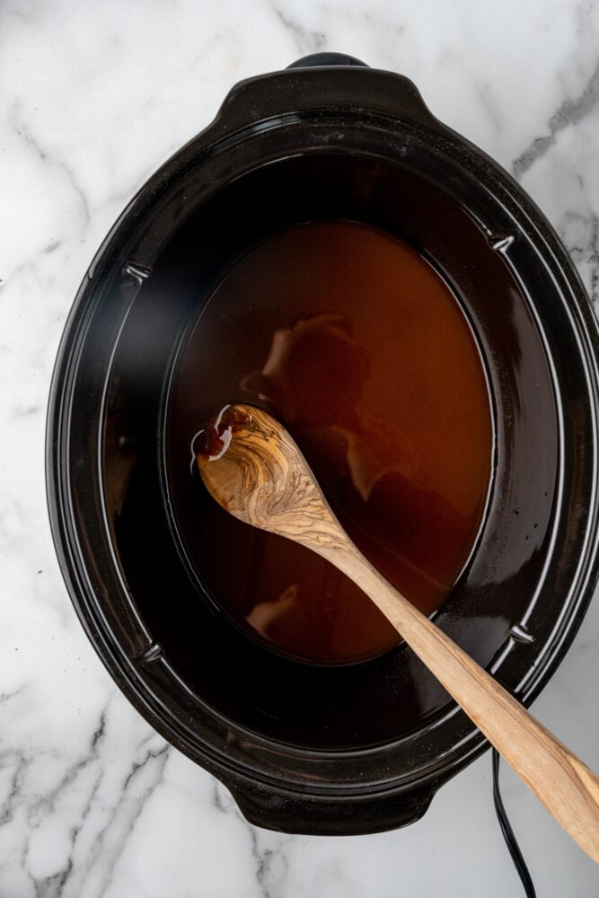 mixing cider and bbq sauce in crock pot