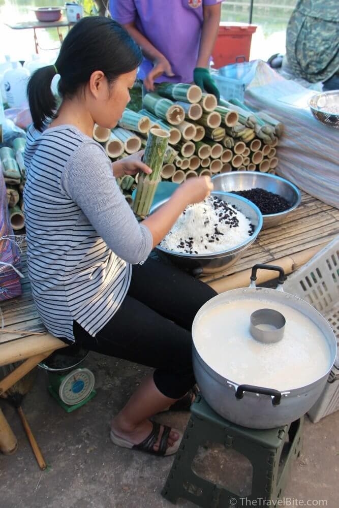 street vendor in Thailand making sweet rice and beans in a bamboo shoot