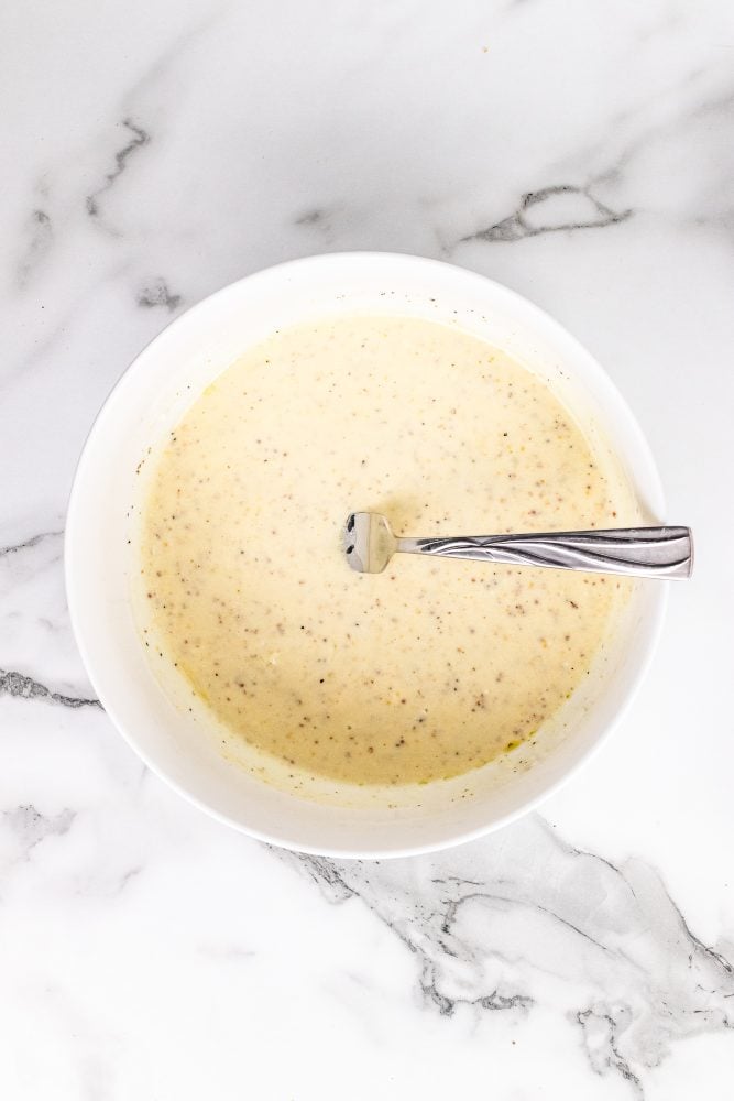 Kale salad dressing blended together in a white bowl.