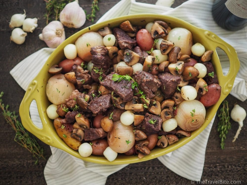 green casserole dish with beef bourguignon