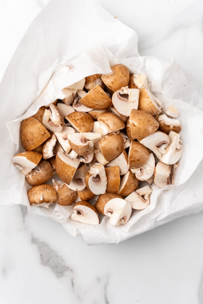 quartered mushrooms drying on a paper towel
