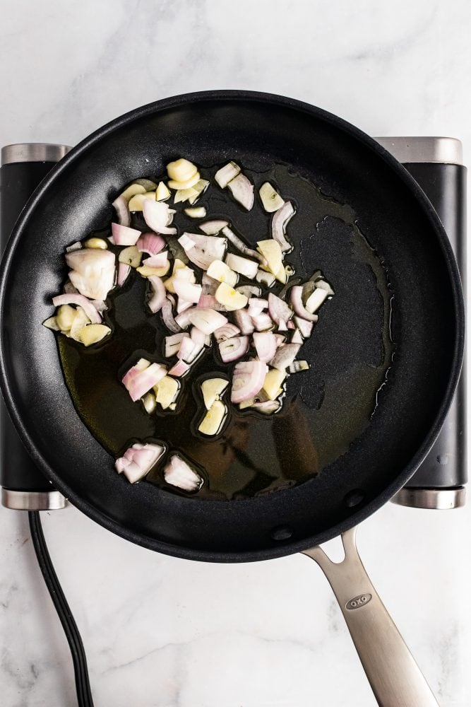 frying shallots and garlic in a frying pan