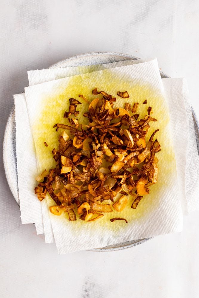 crispy brown shallots and garlic draining oil on paper towels