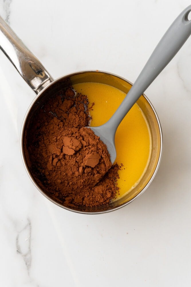 cocoa powder added to sauce pan with coffee and butter
