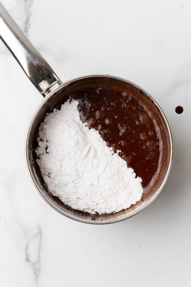 powdered sugar added to sauce pan with cocoa, coffee, and butter