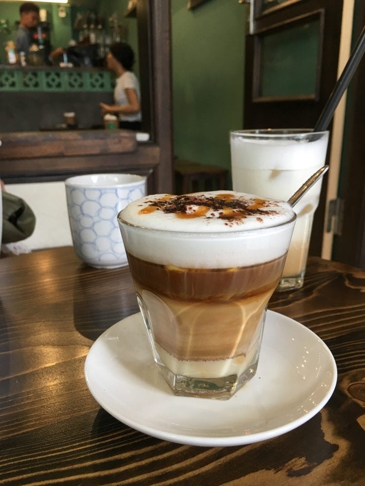 layered coffee drink with a light cream, and dark cream, and foam
