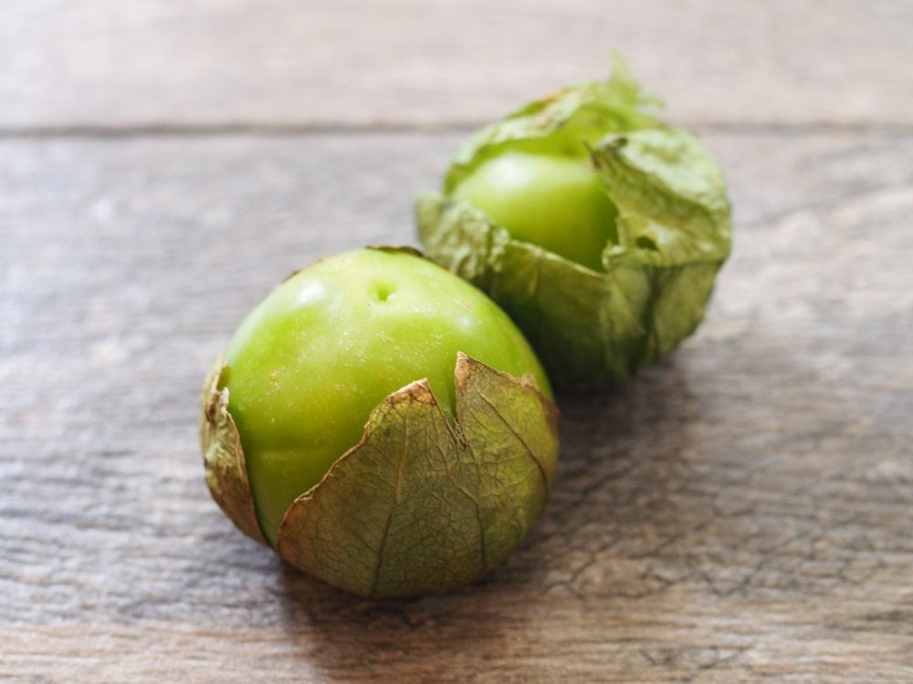 Whole green tomatillos with their papery sheath still attached.