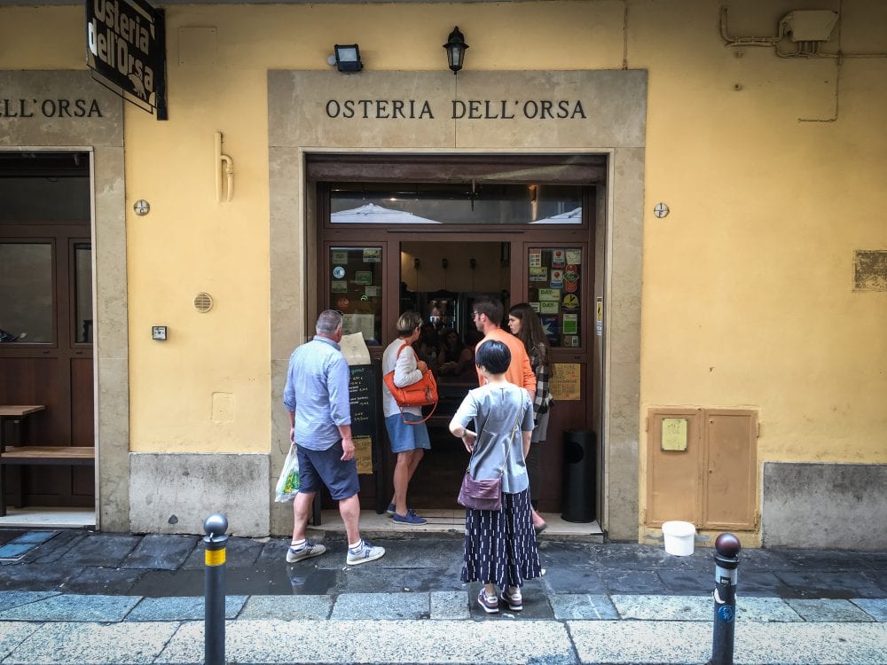 Visitors waiting in line outside of Osteria Dell'Orsa in Bologna, Italy.