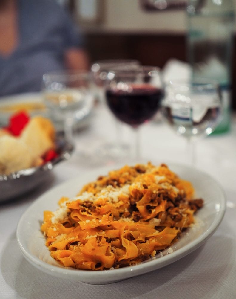 Bologna Food: A plate of Bologna's most famous pasta, tagliatelle al ragu with a glass of Lambrusco wine.