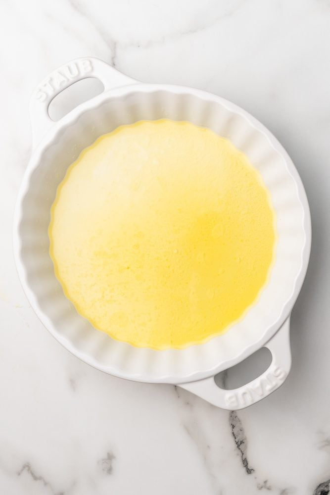 Butter melted and covering the bottom of a white Staub pie dish.