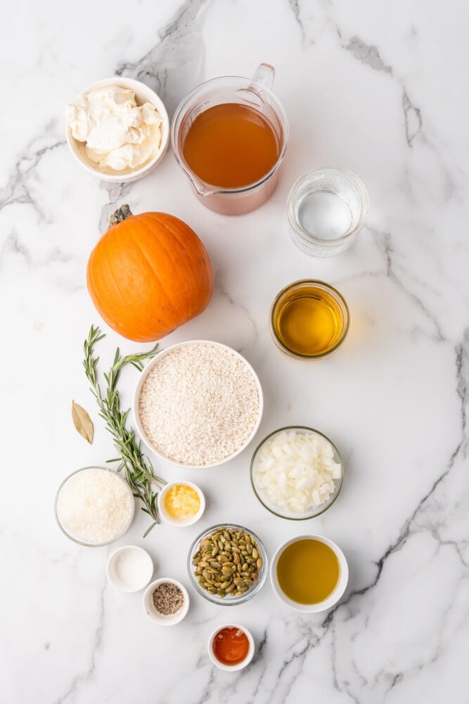Ingredients for pumpkin risotto laid out on marble counter.