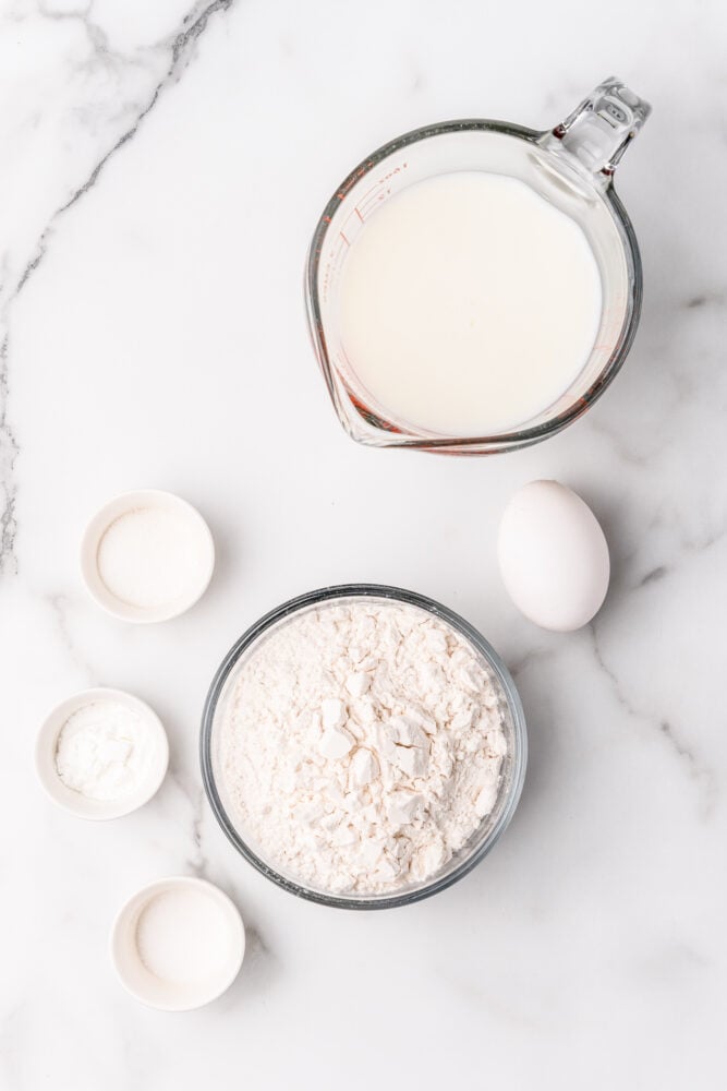 Ingredients for homemade pancakes including flour, sugar, milk, salt, baking powder, and one egg.