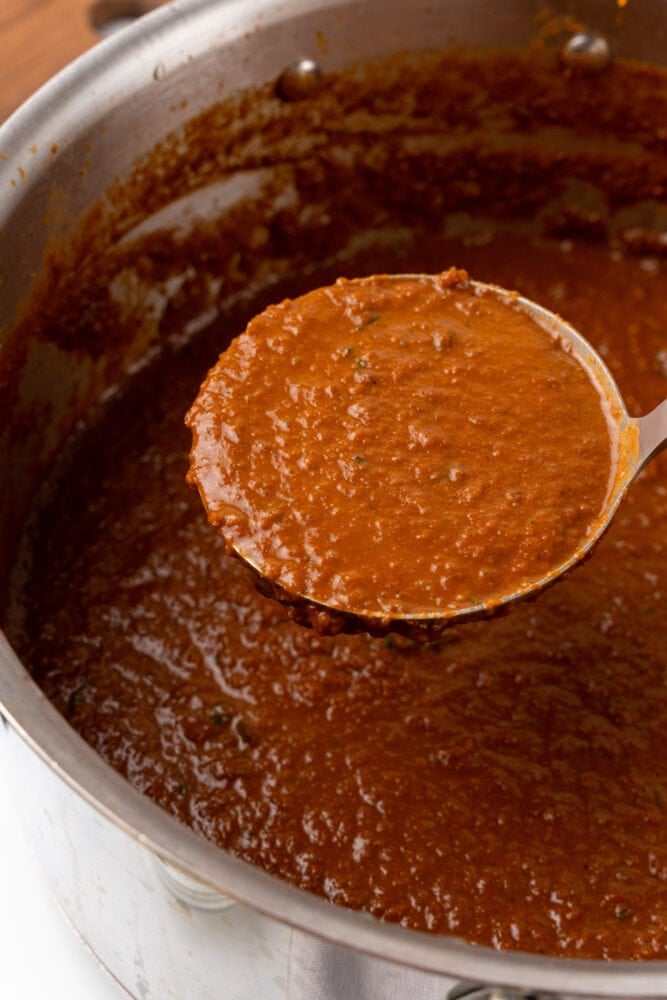 Close up of ladel scooping out serving of spicy tomato soup.