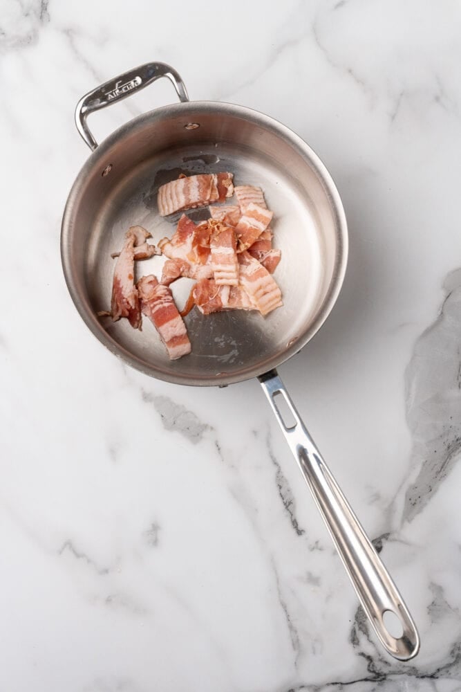 Bacon in a stainless steel soup bowl before being browned.