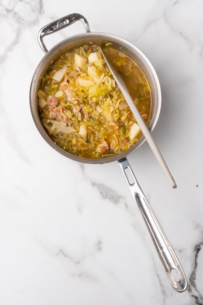 Cooking vegetables in broth for colcannon soup.