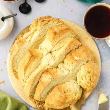 Irish soda bread on a wood cutting board with tea beside it