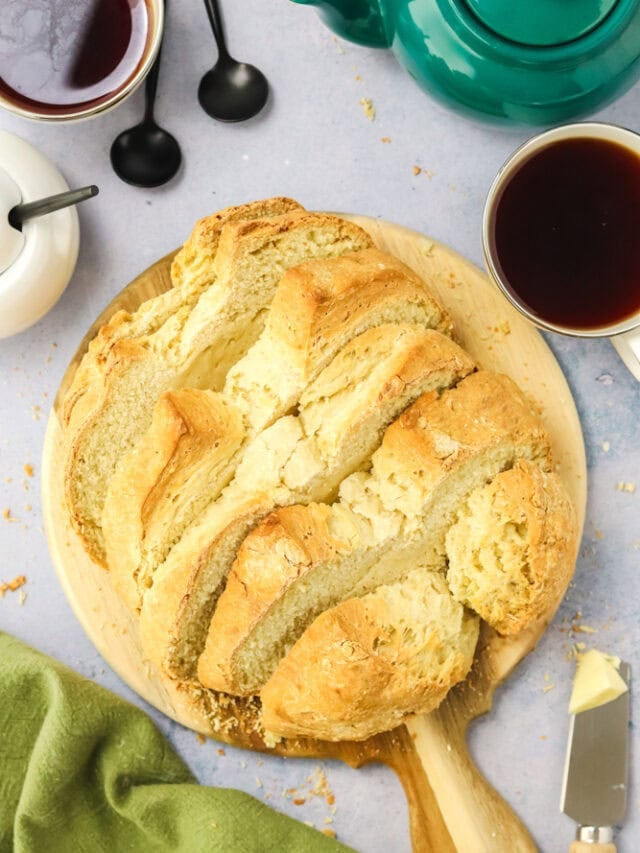 Irish soda bread on a wood cutting board with tea beside it