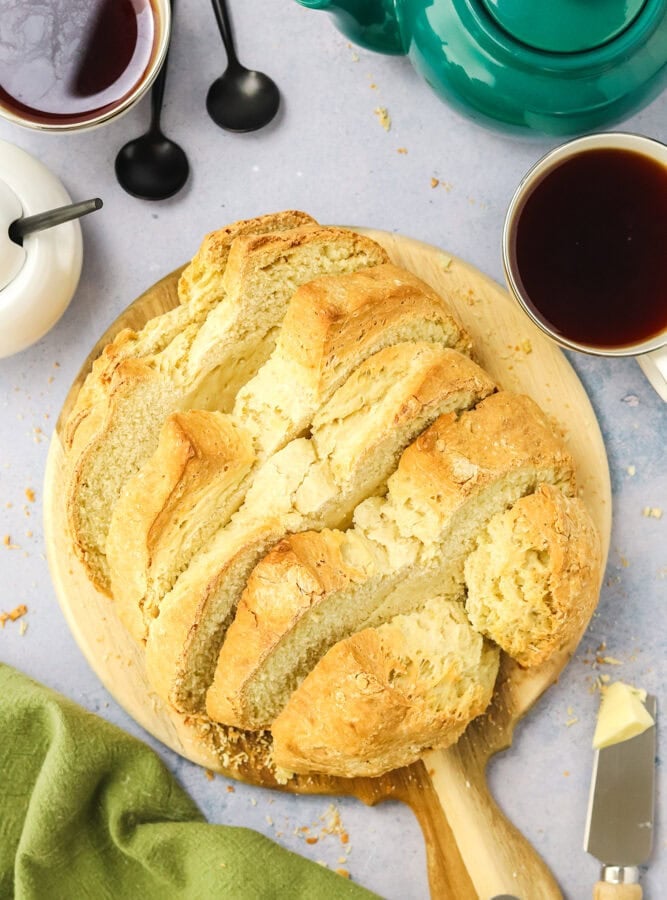 Irish soda bread on a wood cutting board with tea beside it