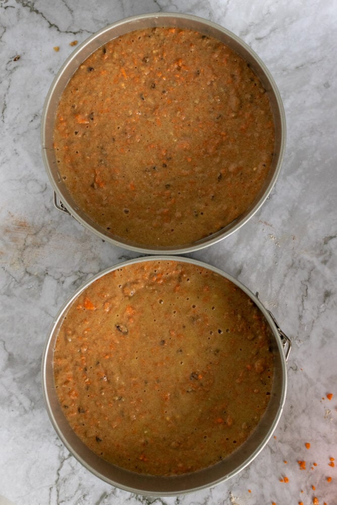 Overhead look into two round cake pans with batter poured in and ready to bake.