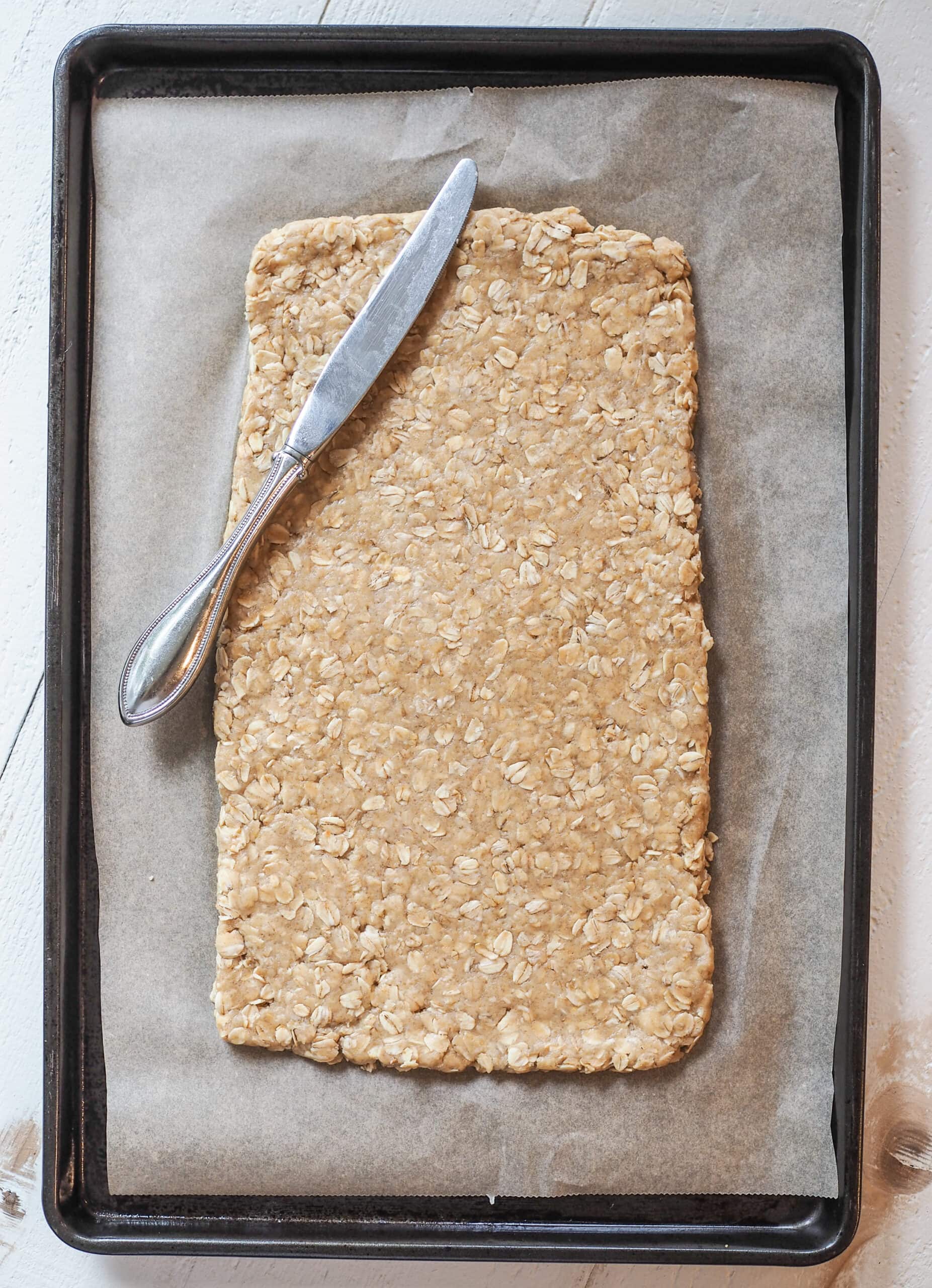 Oatcake dough rolled out onto sheet pan.