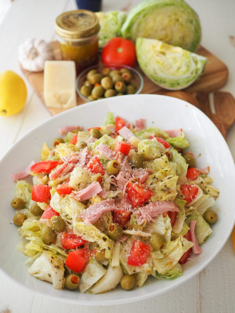 Overhead look at a big bowl of the 1905 salad with romaine lettuce, cubes of ham, Spanish olives, diced tomatoes, and grated parmesan cheese.