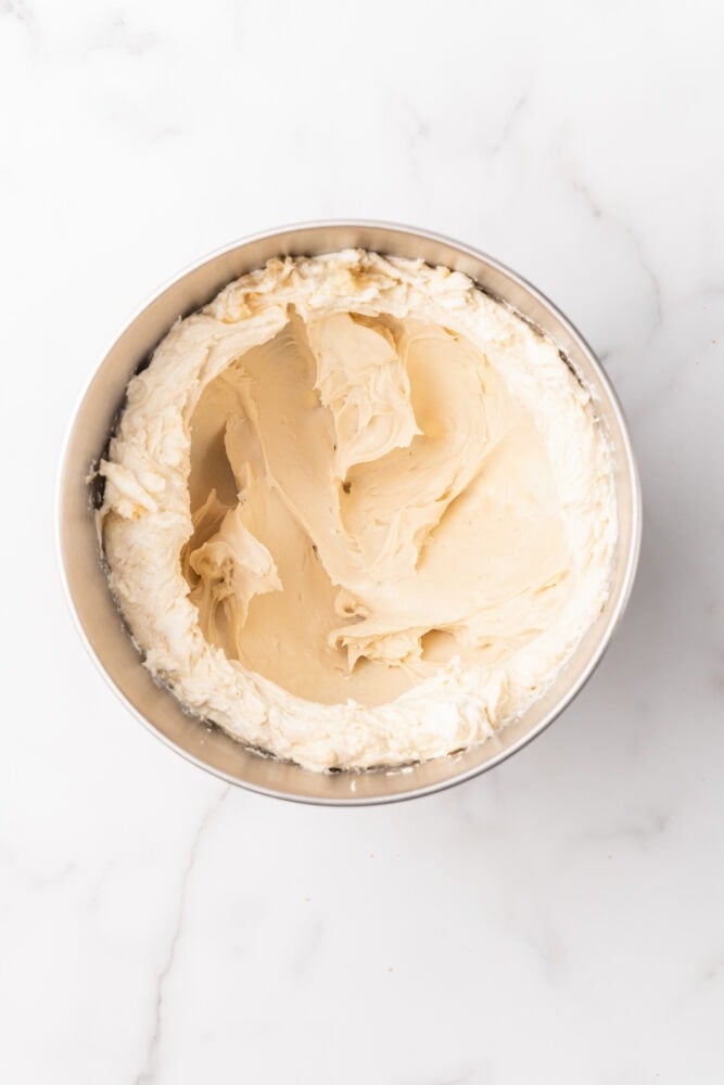 Cream cheese and brown sugar blended in stainless steel bowl.