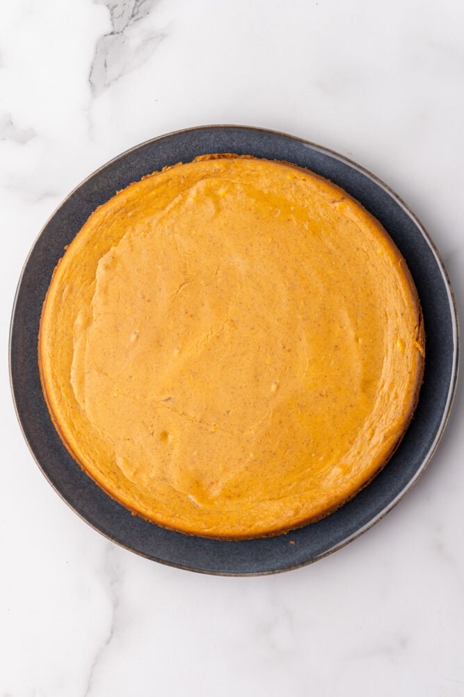 Overhead look at pumpkin cheesecake on black plate.