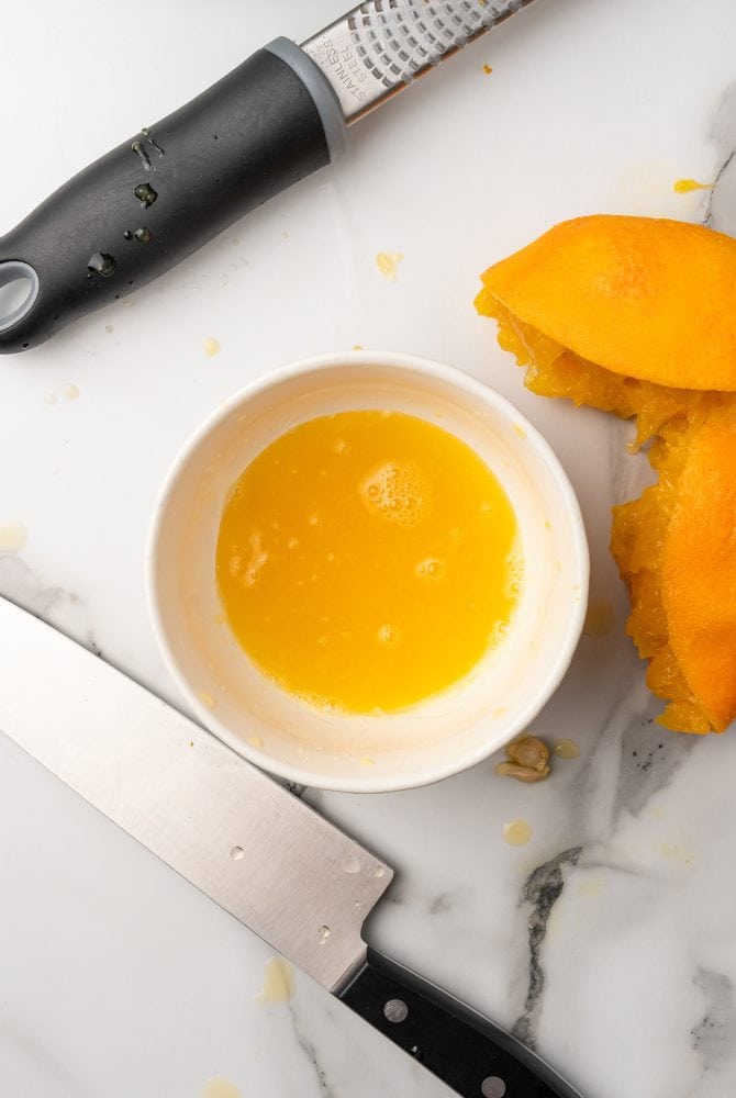 Fresh squeezed orange juice in a small white bowl.