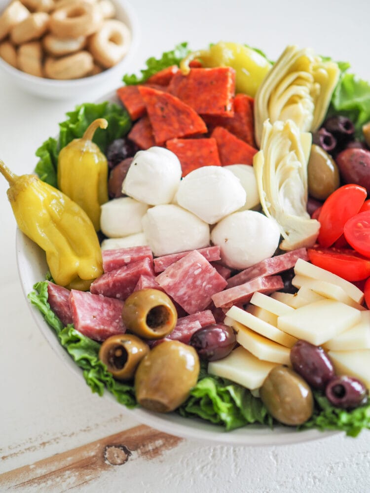 Antipasto Salad with romaine lettuce, salami, soppressata, pepperoncini, olives, mozzarella, provolone cheese, and marinated artichoke hearts. With a side of tarralli crackers.