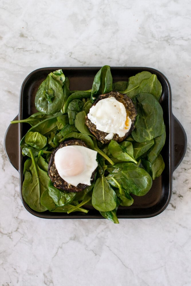 Overhead shot of eggs on portobello mushrooms and spinach.